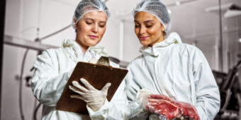 Duas mulheres fazendo análise de carne em frigorífico